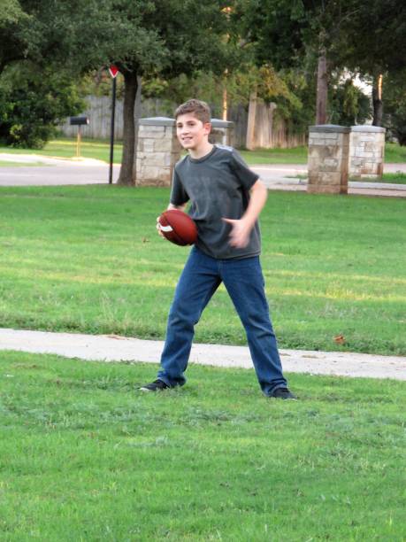 istock boy playing American football 1050055810