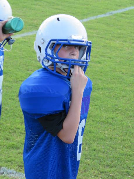 istock boy playing American football 1050055834