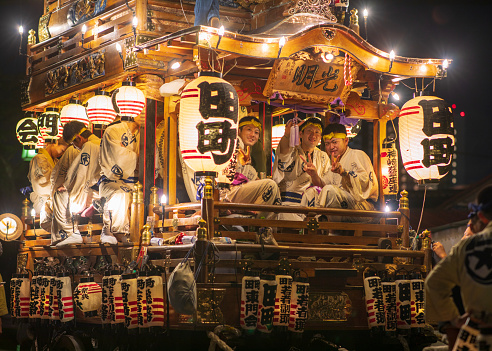 Chiba, Japan - July 6-8, 2018: Local resident playing instrumentals on a huge festival float and pulling it at 'Sobiki' parade in Narita Gion Matsuri (Narita Gion Festival). This sacred festival has continued for over 300 years and it's the biggest event in this city. There are more than 400,000 spectators to see and celebrate the festival.\nThis is a scene of Ohayashi (Japanese instrument) players taking a break on Tamachi Dashi float.