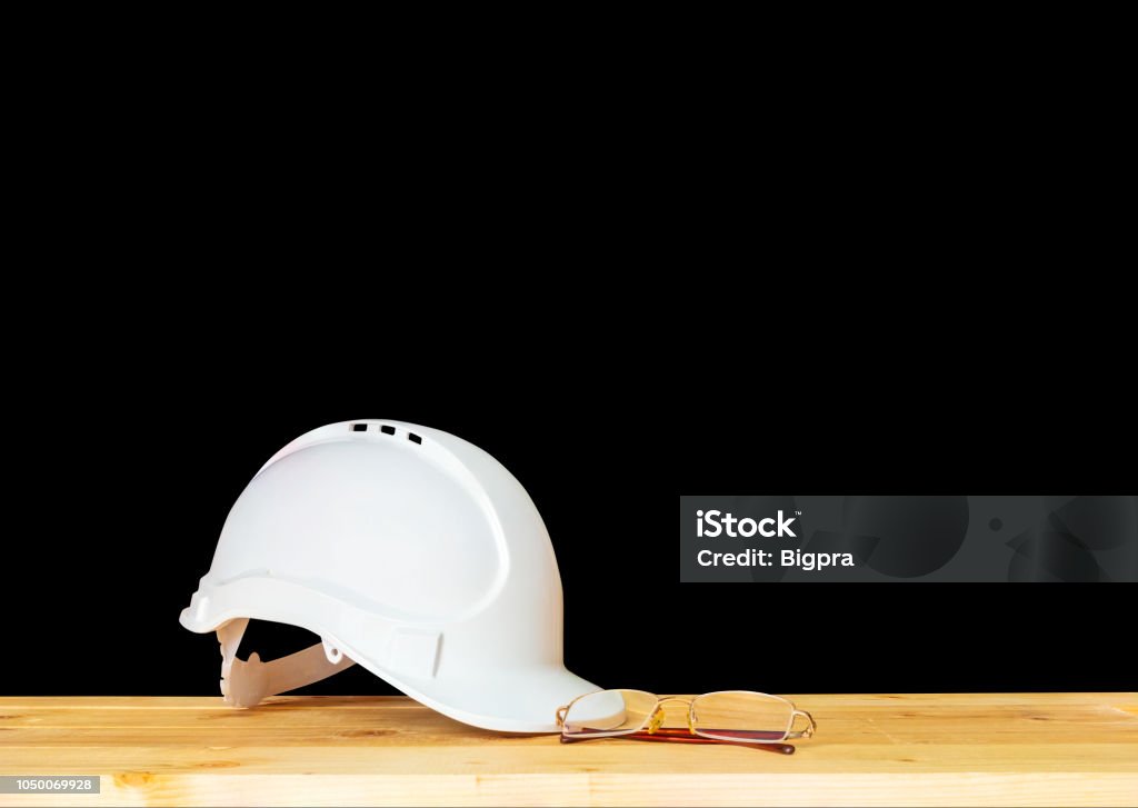 helmet plastic white and glasses. hat safety equipment working of engineering concept construction on Wooden floor isolated black background clipping path Architect Stock Photo