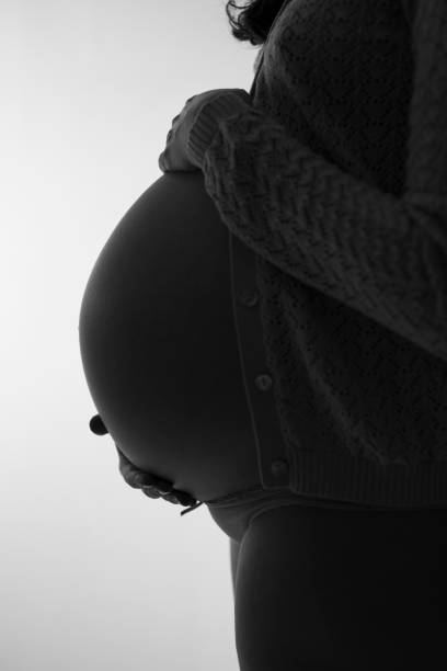 istock Pregnant woman profile back lit portrait 1050072426