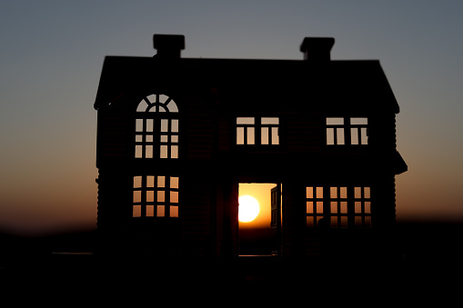 decorative small wooden house on the sunset background. Selective focus