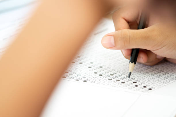 istock Pencil on hand to writing answer of test examination on answer paper 1050085882