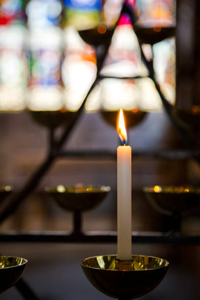 istock Prayer candles burning in a row inside church 1050109456