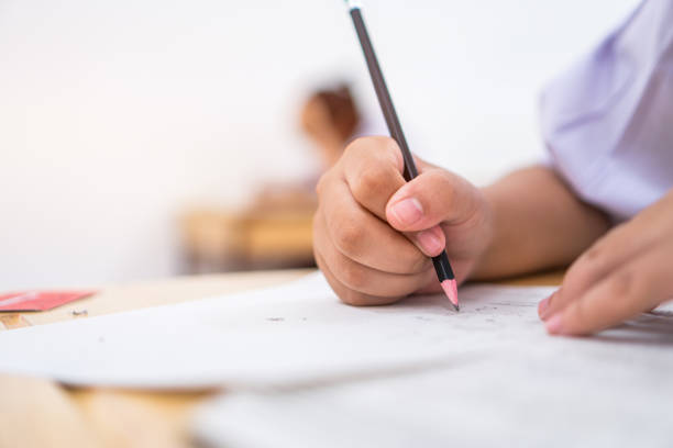 istock Education students testing exam with pencil drawing selected multiple-choice quizzes or testing exams answer sheets exercises in school, college university classroom 1050111768