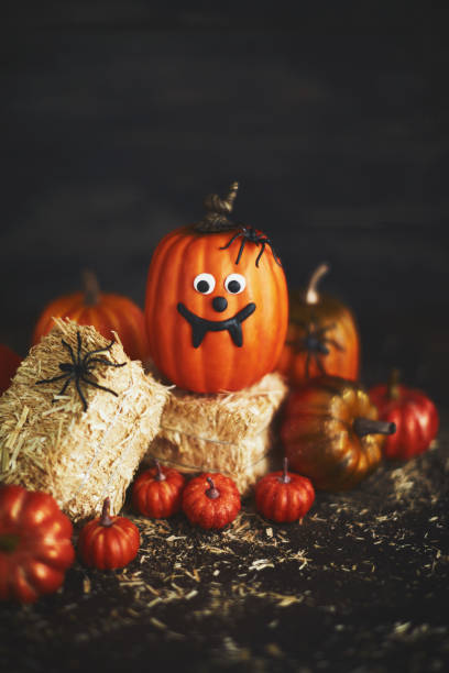 istock Pumpkin with fang face on straw bales 1050119476