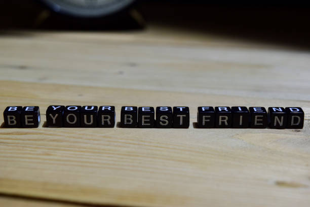 Closeup of the word Love spelled out multiple times over a wood background.