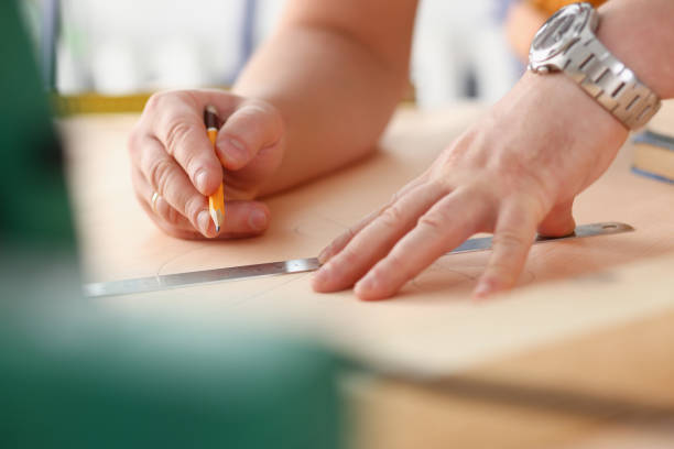 istock Arms of worker making structure plan on scaled paper closeup 1050124582