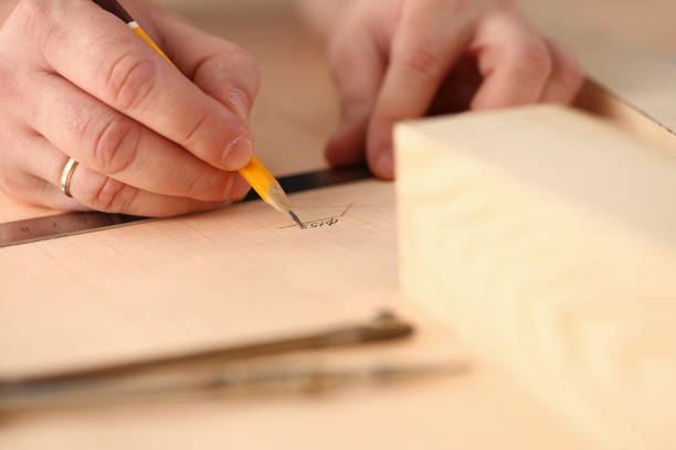 istock Arms of worker making structure plan on scaled paper closeup 1050124612