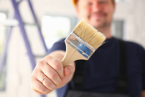 istock Arm of smiling worker hold brush closeup 1050124636