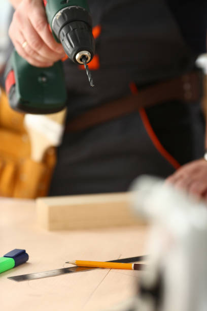 istock Arms of worker using electric drill closeup 1050124668