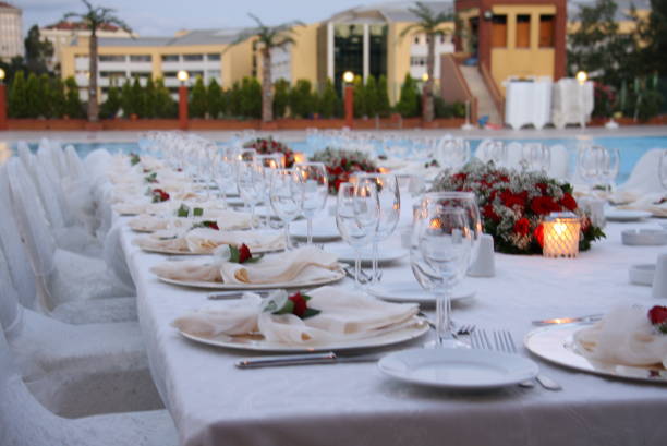 istock table, restaurant, dinner, wedding, glass, setting, food, banquet, wine, celebration, plate, drink, white, party, decoration, reception, dining, catering, event, meal, knife, luxury, wineglass, glasses, arrangement 1050132900