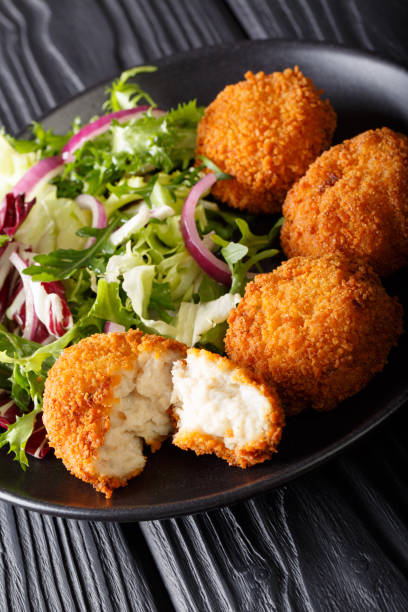 istock Cod cake in breading with fresh mix salad close-up on a plate on the table. vertical 1050141046