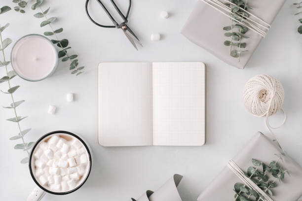 istock An blank notebook among gift boxes and winter festive stuff. The concept of diary , holiday greetings or planning. Flat lay, top view, mockup. 1050151916