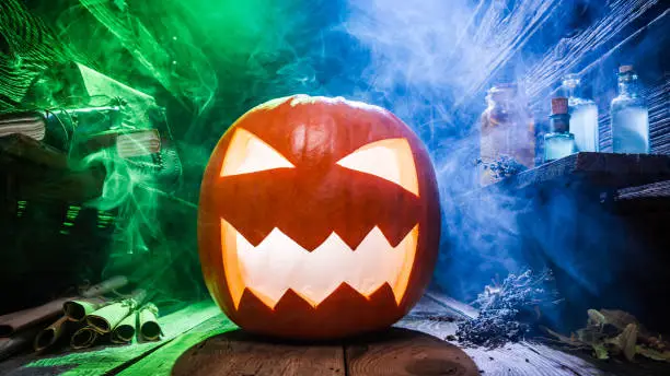 Glowing Halloween pumpkin with blue and green smoke