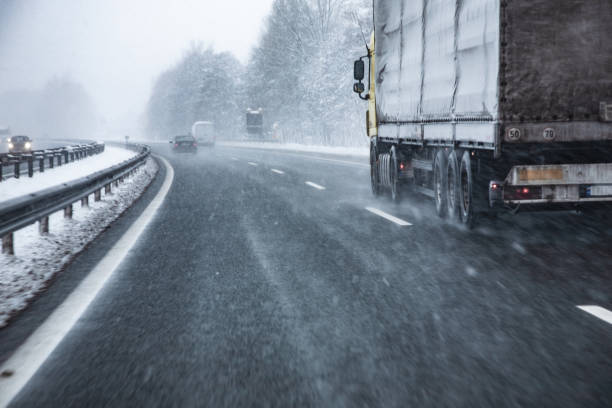 Truck Driving on Wet and Slippery Highway in Winter Truck Driving on Wet and Slippery Highway in Winter. casarsaguru stock pictures, royalty-free photos & images