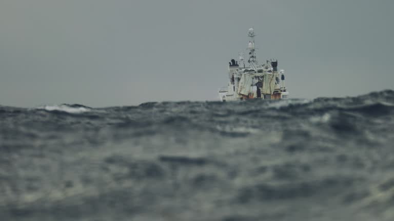 Fishing boat trawler sailing out at rough sea