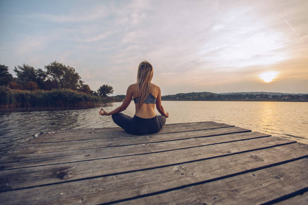 istock Woman practicing yoga by a lake 1050196678