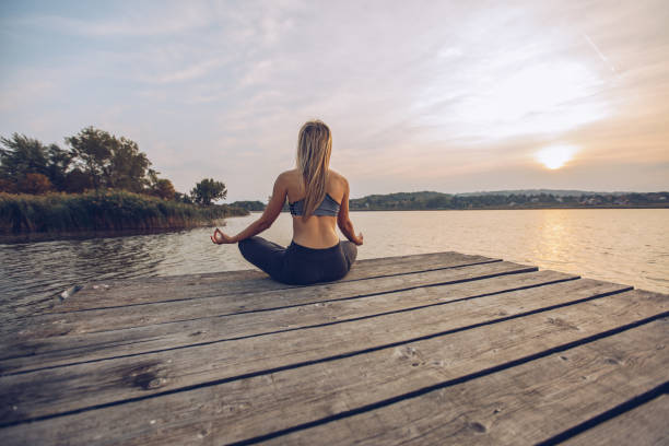 istock Woman practicing yoga by a lake 1050196680