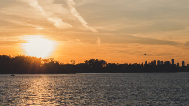 plane tacking off into sunset with lake infront beautiful scene with soft orange color background