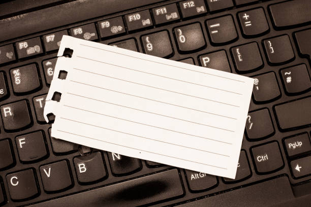 Design business Empty template isolated Minimalist graphic layout template for advertising . Blank Torn Spiraled Page Index Sized Lined Paper Lying on Laptop keyboard