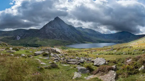 Beautiful panoramic landscape image of countryside around Llyn Ogwen in Snowdonia during early Autumn with Tryfan in background