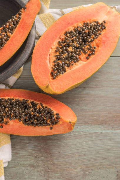 istock Sliced fresh papaya on wooden background. Top view with copy space 1050241918