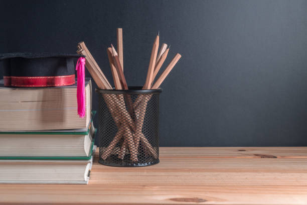 istock graduation hat on Stack of books with pencils on the wooden table 1050243728