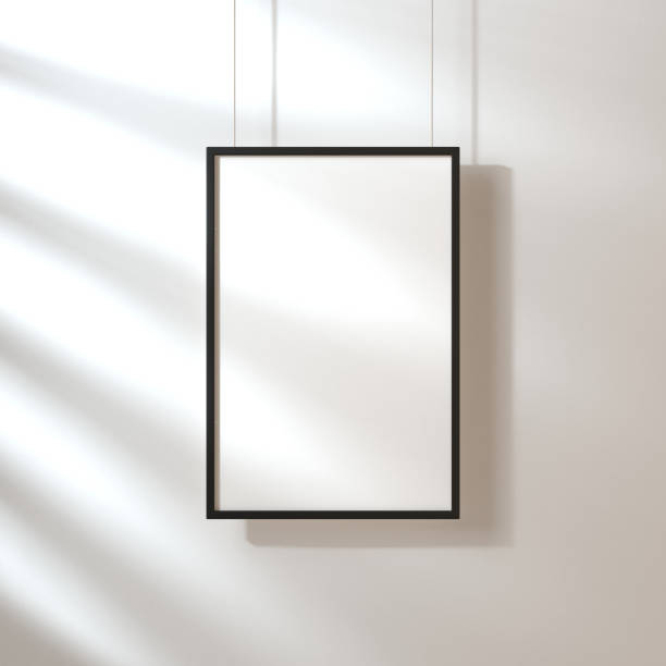 istock White poster with black frame mockup hanging on the wall with shadows 1050245952