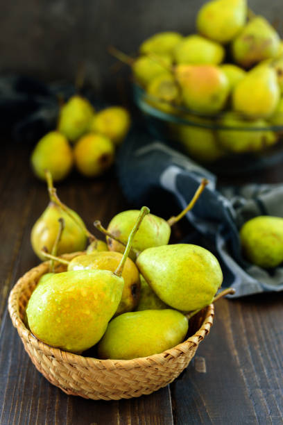 istock Fresh garden pears on dark wooden table 1050246116