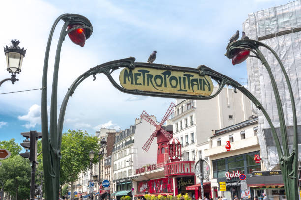 Metro sign and Moulin Rouge cabaret in Paris, France PARIS, FRANCE - Circa May 2018: Metro sign and Moulin Rouge cabaret in Paris place pigalle stock pictures, royalty-free photos & images