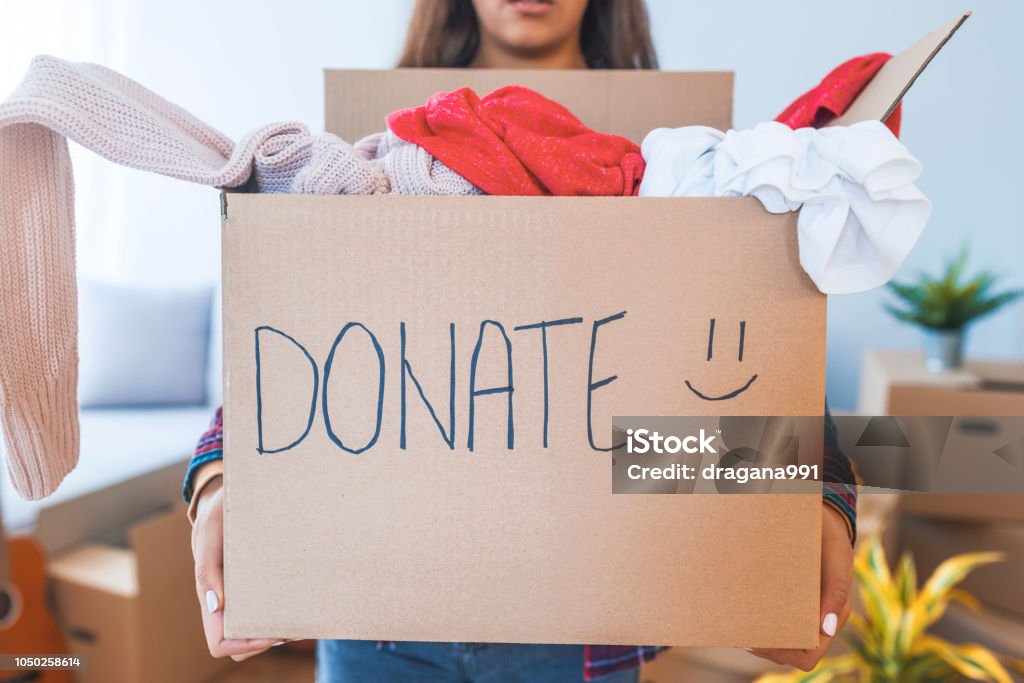 Giovane donna con scatola di donazione a casa - Foto stock royalty-free di Donazione