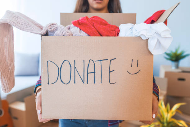 giovane donna con scatola di donazione a casa - volunteer organized group casual charity and relief work foto e immagini stock