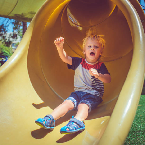 istock Happy child having fun while sliding at playground 1050258778