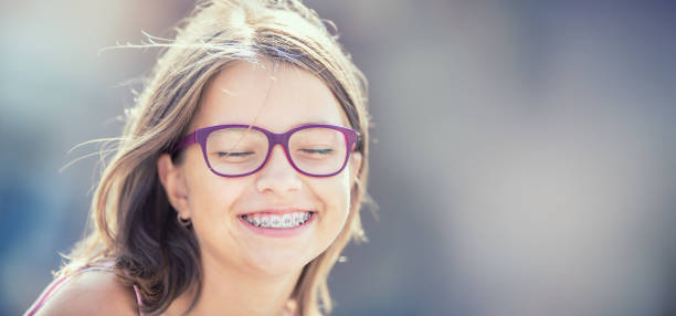 portrait d’une adolescente souriante heureuse avec bretelles dentaires et les lunettes. - dentists chair people care medical equipment photos et images de collection