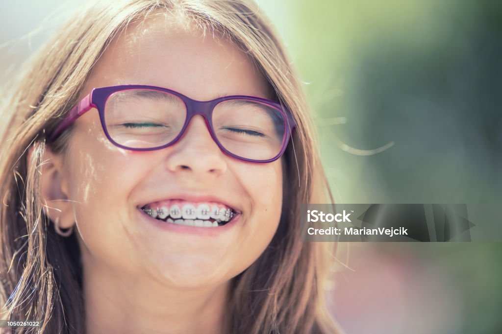 Porträt eines glücklich lächelnden Mädchens mit Zahnspangen und Gläser. - Lizenzfrei Zahnspange Stock-Foto