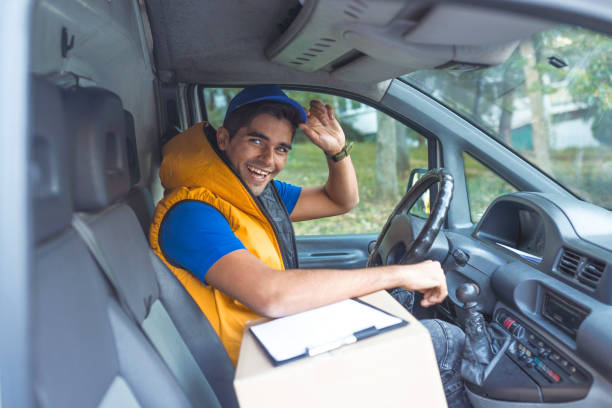 delivery man checking list in van - postal worker truck driver delivering delivery person imagens e fotografias de stock