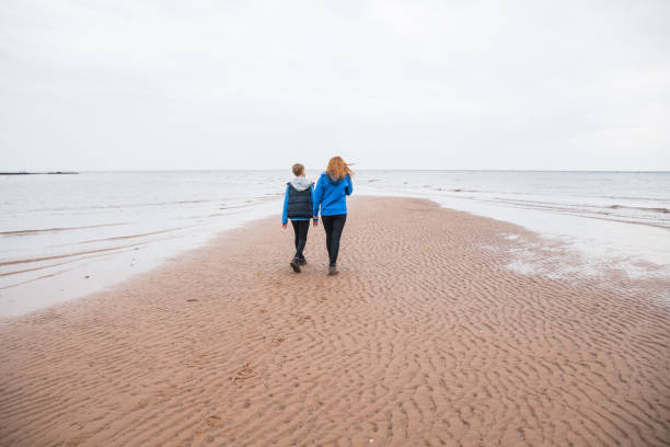 istock Brother and sister walk on the beach in Cornwall, UK 1050267574
