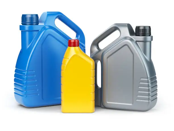 Photo of Different types of plastic canisters of motor oil on white isolated background.