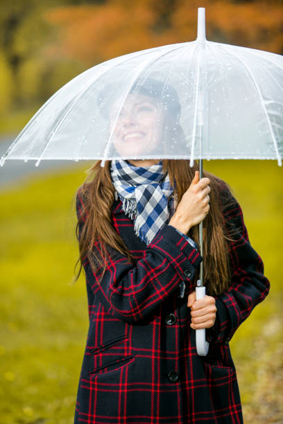 istock Happy woman holding an umbrella 1050280742