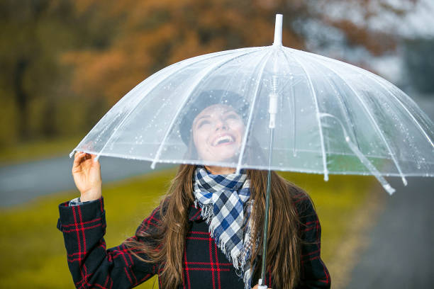 istock Happy woman holding an umbrella 1050280834