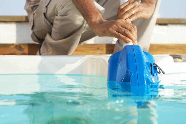 Hotel staff worker cleaning the pool
