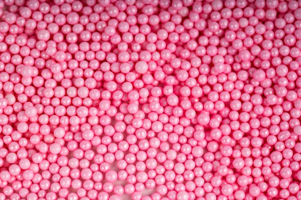 istock pink sugar candy balls stacked on white background 1050287854