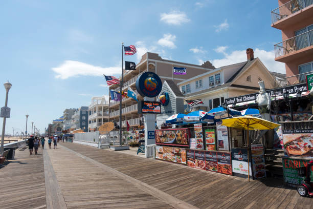 Ocean City, USA - September 3, 2018. Restaurant menu posters with people walking on boardwalk at Ocean City, Maryland, USA.