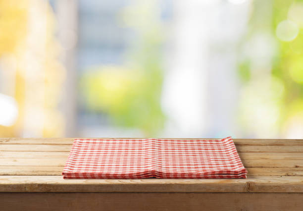 istock Empty wooden table with tablecloth over abstract bokeh background. 1050297478