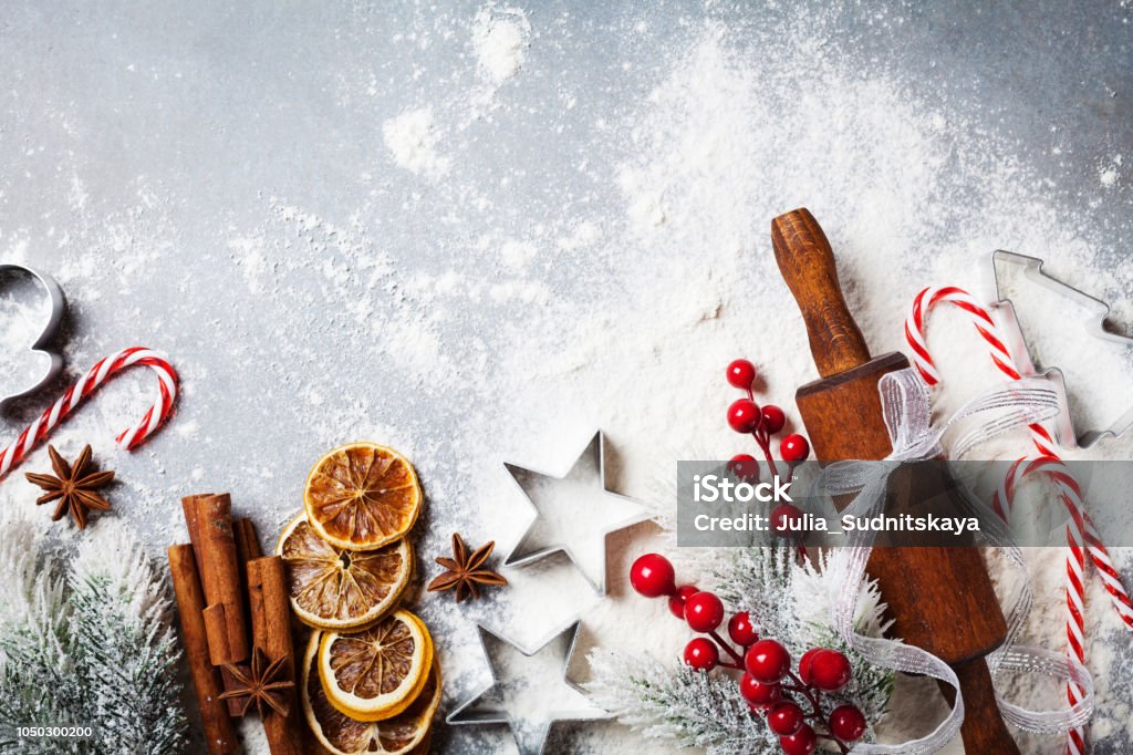 Bakery background for cooking christmas baking with rolling pin, scattered flour and spices decorated with fir tree top view. Bakery food background for cooking christmas baking with rolling pin, scattered flour and spices decorated with fir tree top view. Christmas Stock Photo