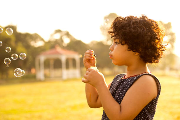 istock Little girl blowing bubbles 1050300884