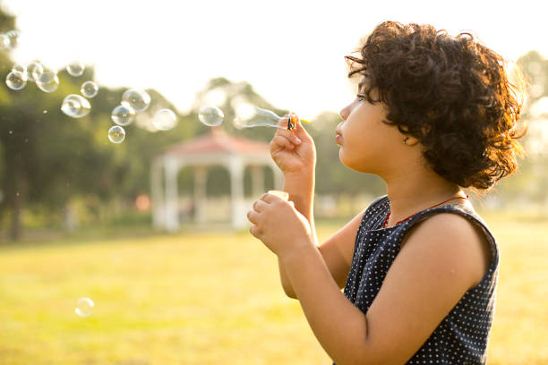 istock Little girl blowing bubbles 1050301208