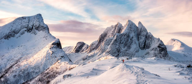 panorama of mountaineer standing on top of snowy mountain range - norway island nordic countries horizontal imagens e fotografias de stock