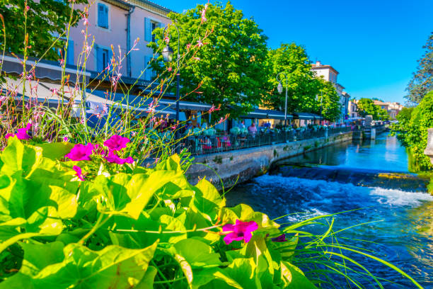 bicicleta presa a uma grade no centro histórico de l'isle sur la sorgue em frança - lisle - fotografias e filmes do acervo